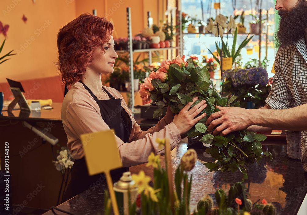 Bearded male buying bouquet of flowers at floral shop.