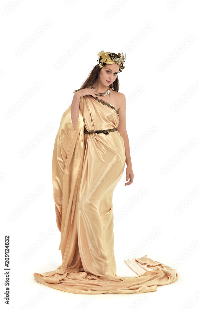 full length portrait of brunette woman wearing long golden grecian gown, standing pose. isolated on white studio background.