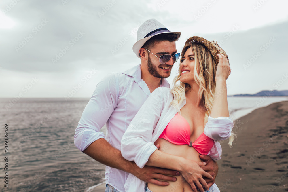 Lovers couple in love having fun dating on beach.