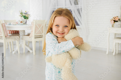 Little girl hugs a teddy bear. Smiles, emotions of happiness. Little girl playing with teddy bear