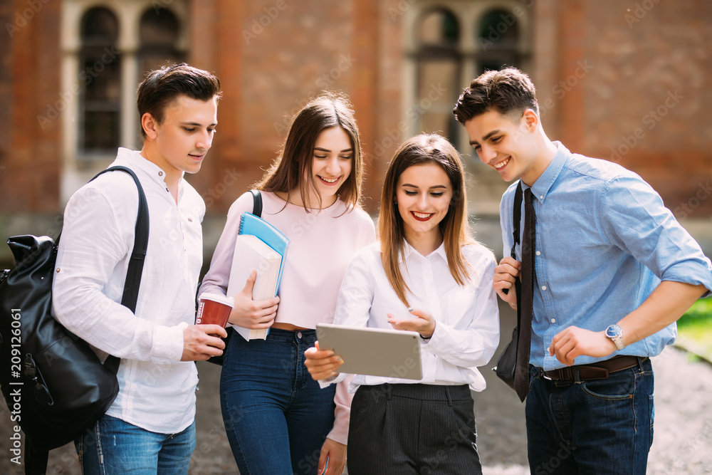 Group of students studying together outdoors in a college campus Group of students studying together outdoors in a college campus