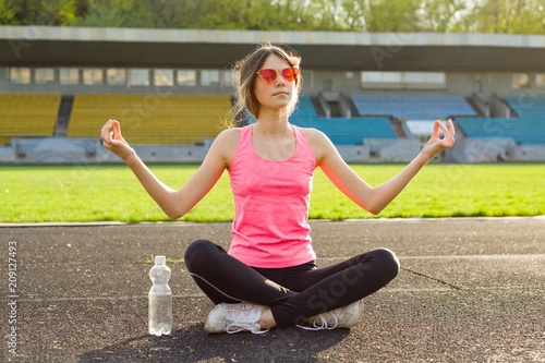 Young beautiful teenage girl practicing yoga in the stadium © Valerii Honcharuk