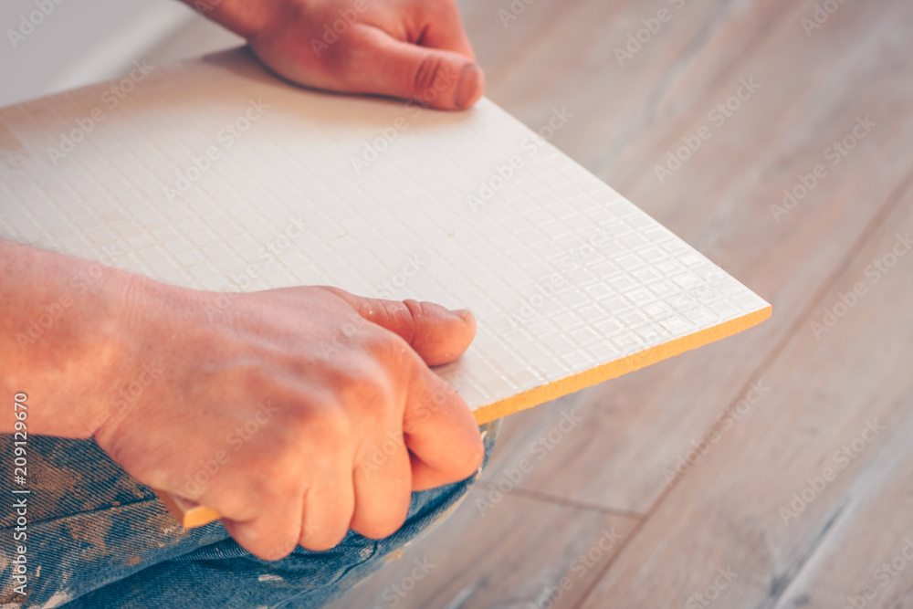 Worker breaks the cut tile on a curved line by hand Stock Photo Adobe