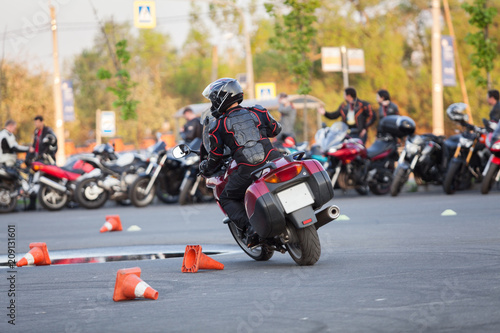 Motorbike driver riding bike on urban square using it as motordrome, rear view