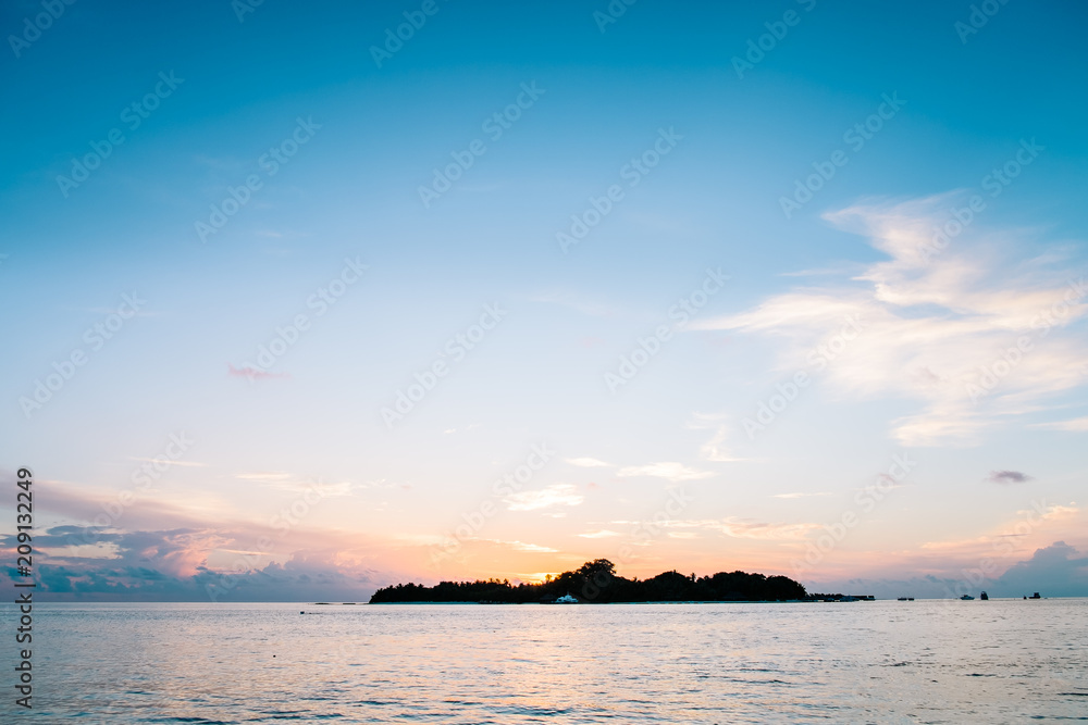 Amazing tropical landscape view. Colorful sky and clouds view with calm sea and relaxing tropical mood. Gorgeous nature background. Maldives, Indian Ocean.
