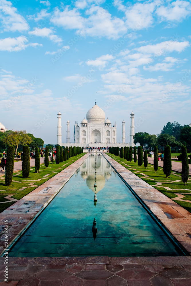 Taj Mahal front view reflected on the reflection pool, an ivory-white marble mausoleum on the south bank of the Yamuna river in Agra, Uttar Pradesh, India. One of the seven wonders of the world.