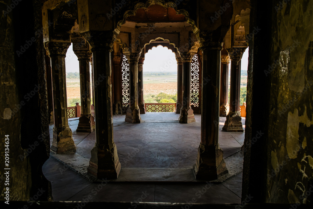 View of white marble buildings and palaces through an arch inside Agra Fort fortress UNESCO heritage site in Agra, India. Mughal Islamic architecture in Uttar Pradesh.