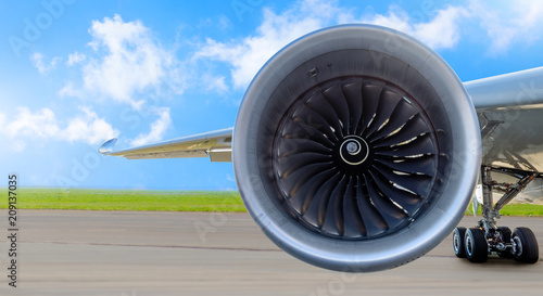 Aircraft jet engine close-up, airplane wing and chassis of landing gear wheel parked at the airport on a sky clouds background, panorama.