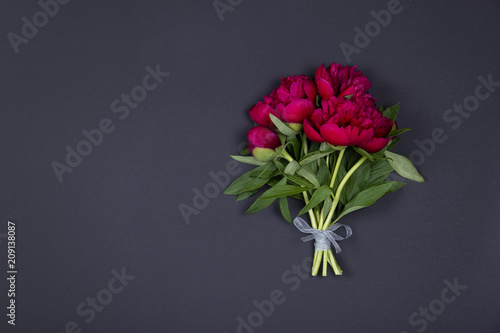 Peonies flowers bouquet on dark background with copy space.