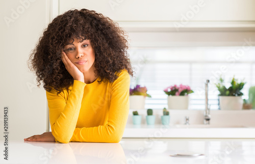 African american woman wearing yellow sweater at kitchen thinking looking tired and bored with depression problems with crossed arms.