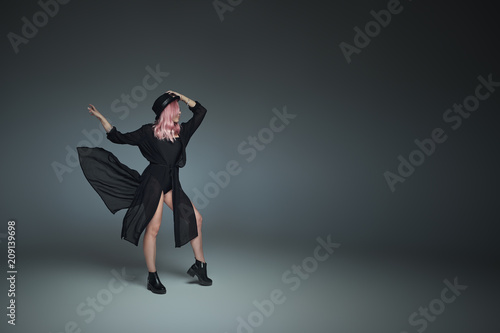 Fashionable girl with pink hair, wearing black flying outfit