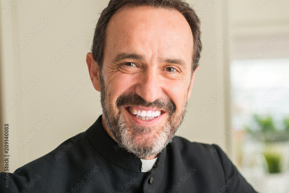 Fototapeta premium Christian priest man with a happy face standing and smiling with a confident smile showing teeth