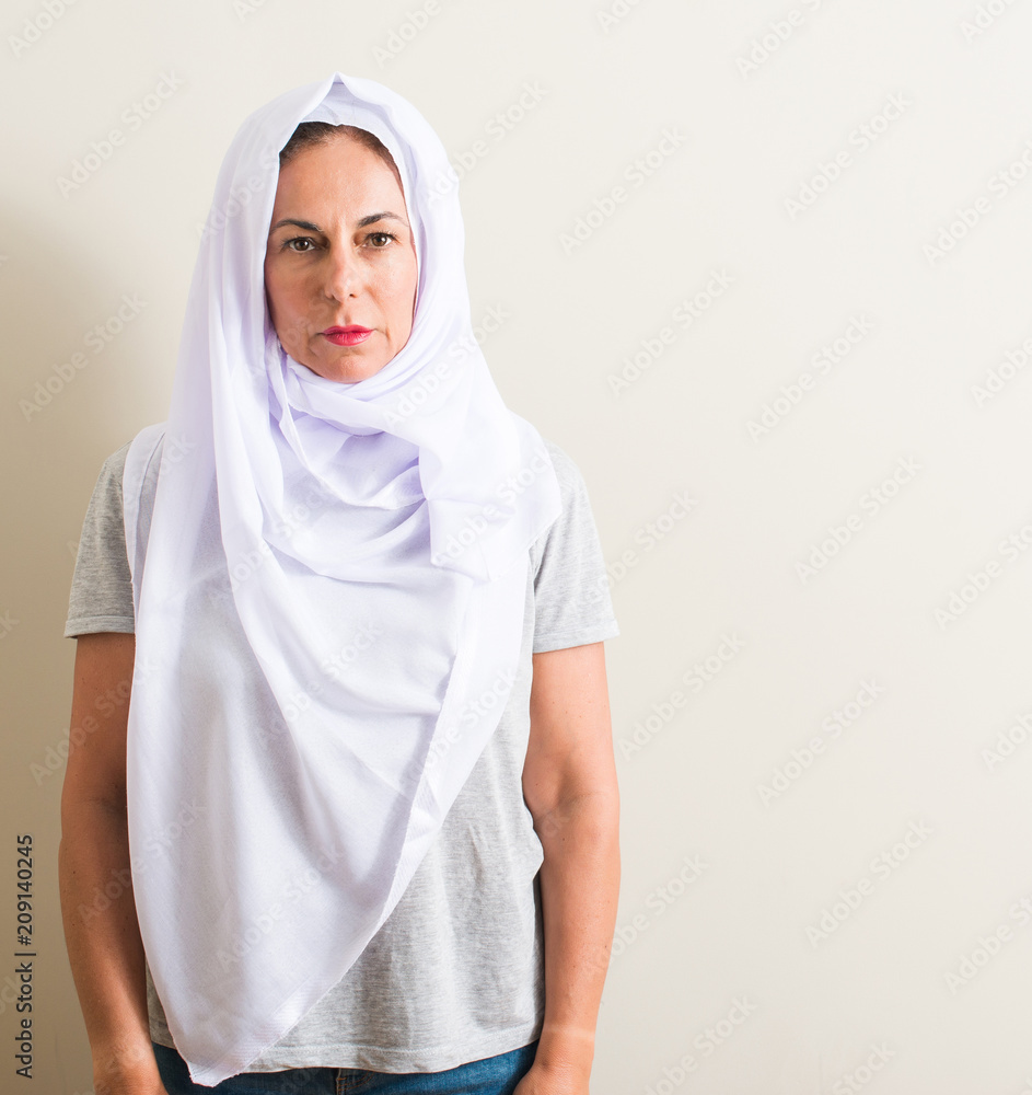 Middle age arabian woman wearing white hijab with a confident expression on smart face thinking serious Middle age arabian woman wearing white hijab with a confident expression on smart face thinking serious
