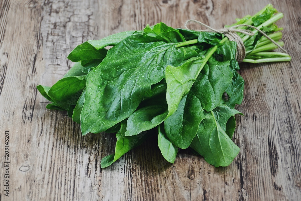 Fresh spinach isolated on wooden background Fresh spinach isolated on wooden background