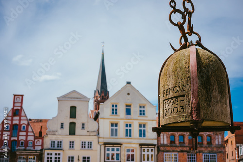 Weight of old Crane hanging in front of facade of historical buildings in Harbor Lueneburg, Lower Saxony,Germany photo