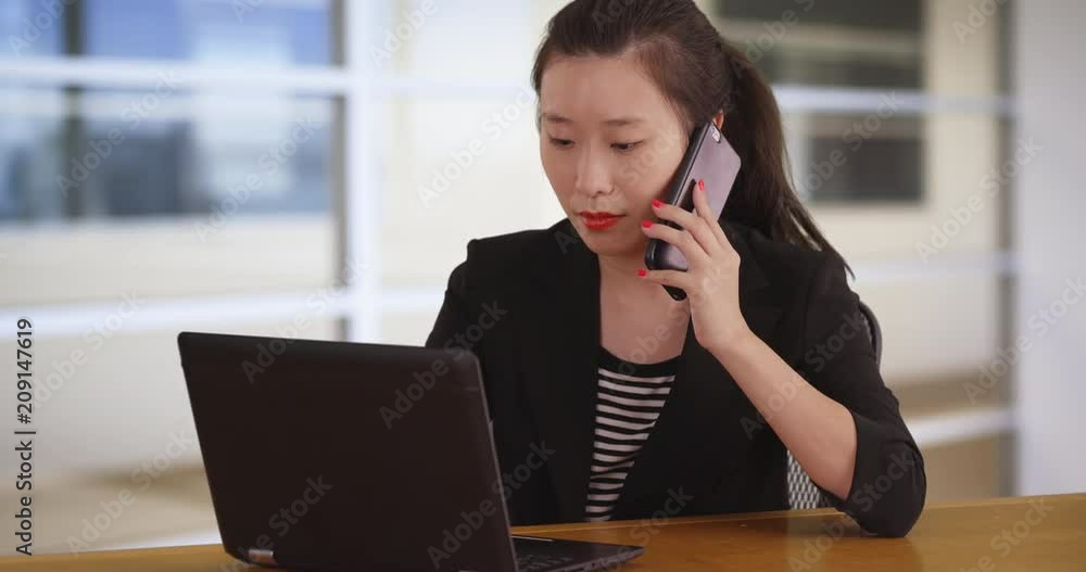 Portrait of millennial businesswoman talking on smartphone while using computer in office workplace, Closeup of brilliant young social worker multitasking at work, 4k Portrait of millennial businesswoman talking on smartphone while using computer in office workplace, Closeup of brilliant young social worker multitasking at work, 4k