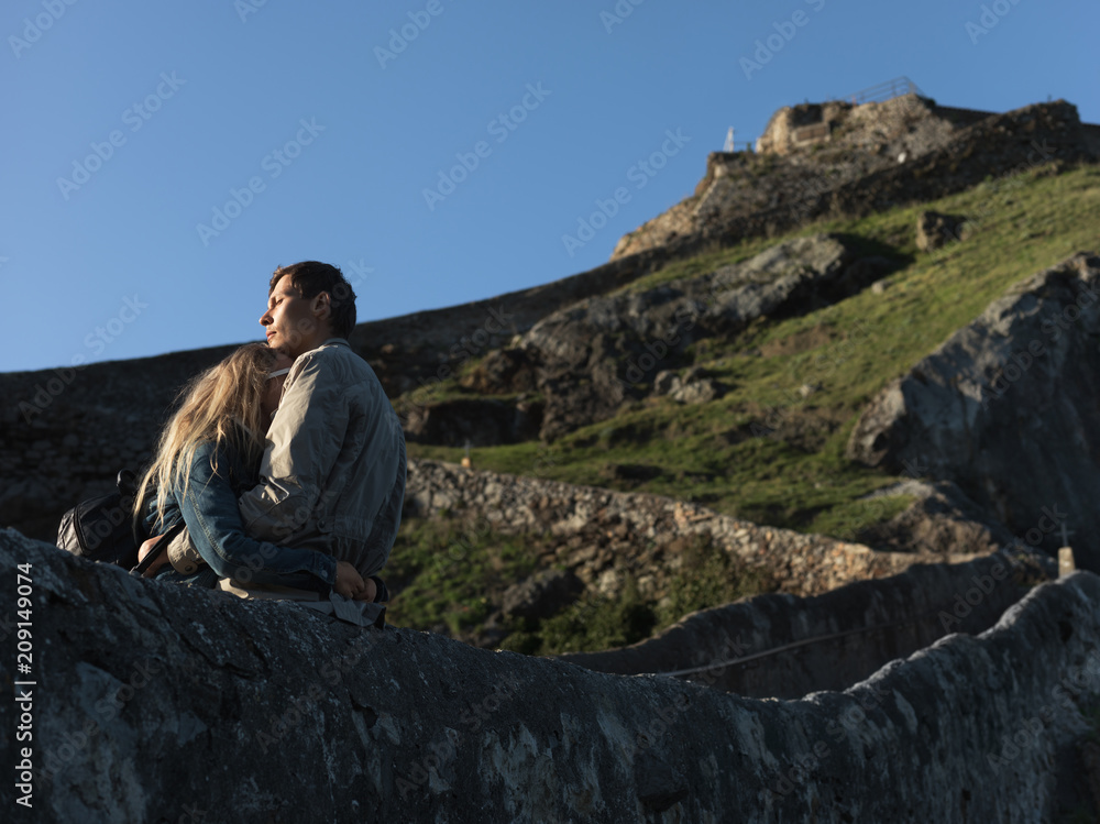 Couple standing on walkway in hills Couple standing on walkway in hills