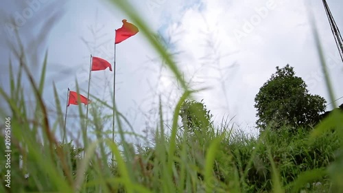 Three national chinese red flags waving in the wind outdoors in the field. photo