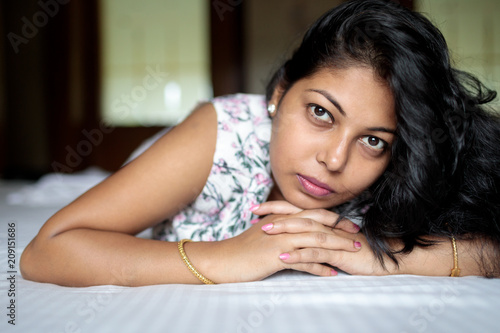 Close up portrait of beautiful young woman lying on bed photo