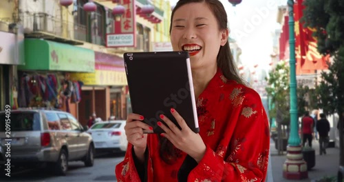 Close up of cute millennial woman video chatting using tablet computer in China Town San Francisco, Young female millennial having video chat with portable tablet device in urban setting, 4k