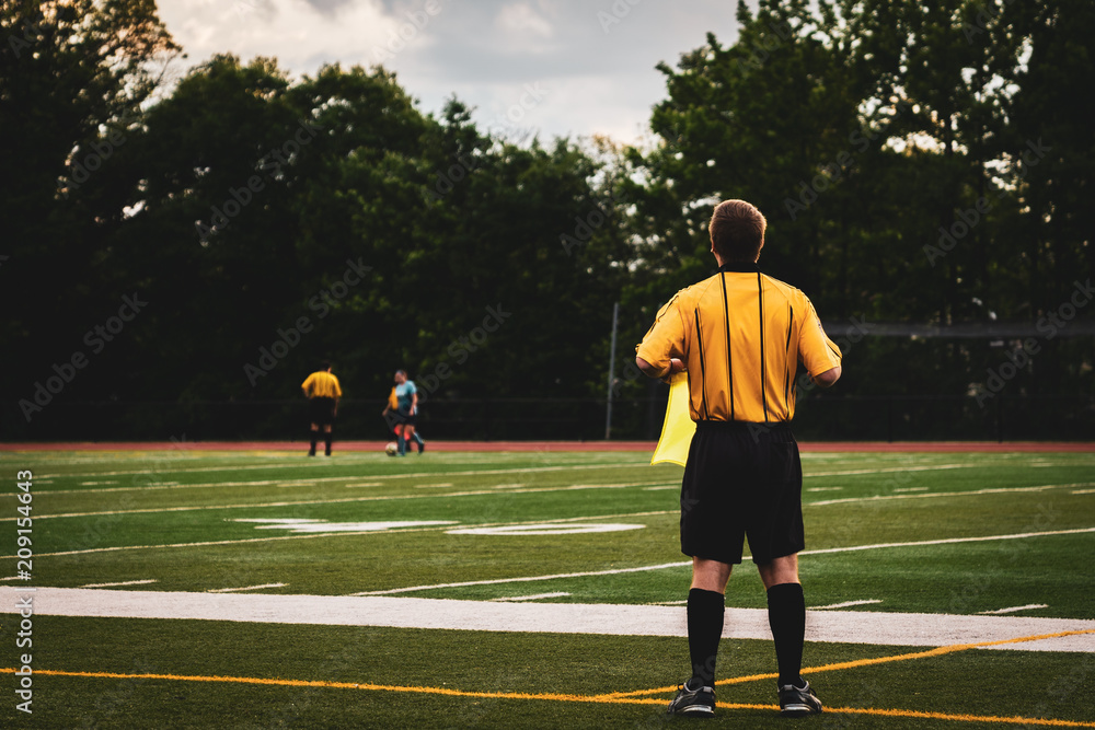 Soccer Referee with Yellow Top and Black Pants at youth girls soccer game Soccer Referee with Yellow Top and Black Pants at youth girls soccer game