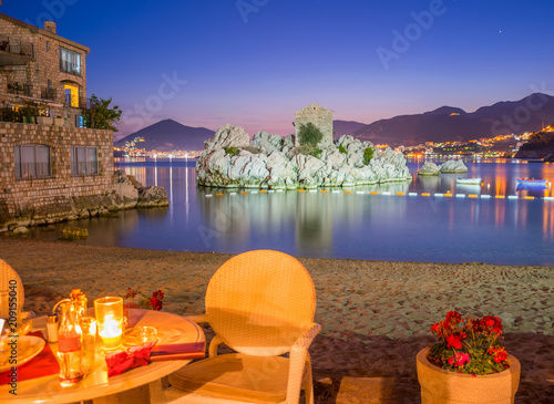 MONTENEGRO, PRZNO - JUNE 05/2017: the restaurant staff prepared their tables near the sea for dinner during sunset.