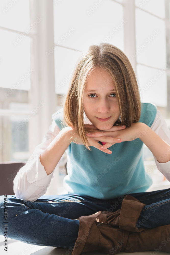 tween girl sitting cross-legged on table, looking at camera Stock Photo ...