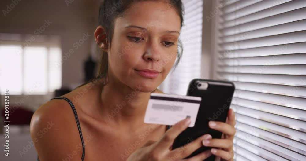 Close-up of cheerful Caucasian woman holding credit card and mobile phone shopping online, Portrait of young woman purchasing goods on Internet from comfort of home, 4k Close-up of cheerful Caucasian woman holding credit card and mobile phone shopping online, Portrait of young woman purchasing goods on Internet from comfort of home, 4k