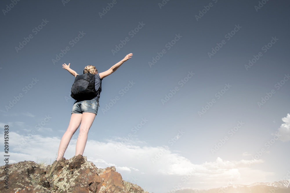 Successful woman hiker enjoy the view on cliff edge top of mountain. The goal is achieved! Successful woman hiker enjoy the view on cliff edge top of mountain. The goal is achieved!