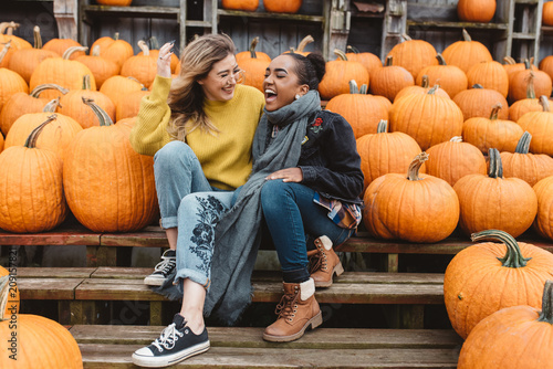 Two best friends in their twenties at a pumpkin patch photo