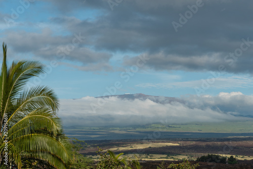 Dramatic sky over the Kohala coast on the Big Island of Hawaii at sunset with Mauna Kea peak in the background