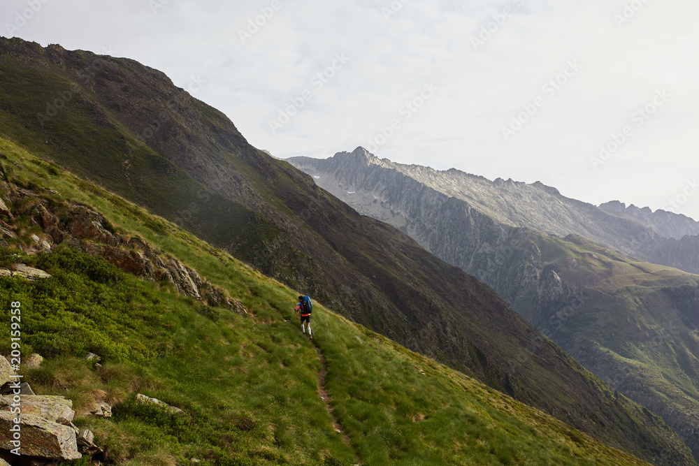 Scenic moutain landscape with little silhouette of backpacker hiking up Scenic moutain landscape with little silhouette of backpacker hiking up