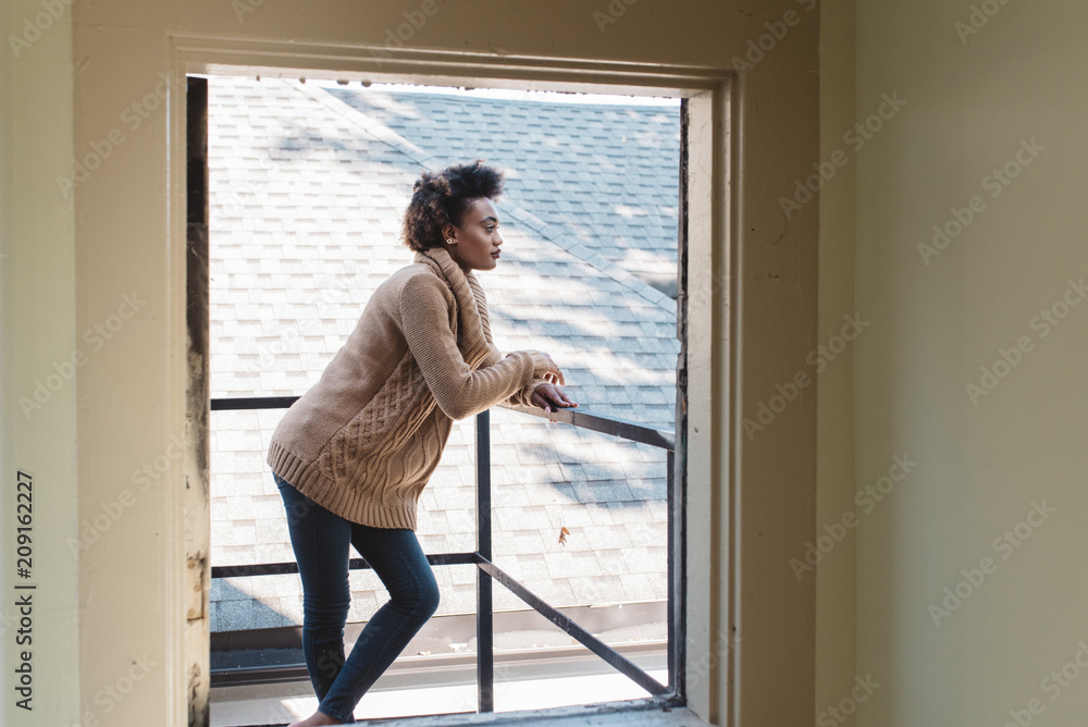 A young woman on the deck of her apartment A young woman on the deck of her apartment