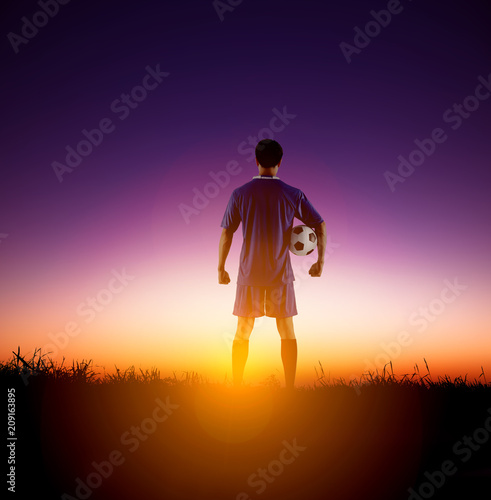 rear view soccer football player watching the sunrise