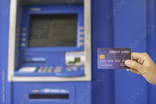 Hand inserting with a credit card into bank machine . Man using an atm machine with  credit card to withdraw money