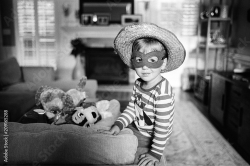 Cute young boy dressed up wearing a mask and sombrero photo