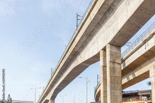 double berth metro train bridge construction and train seen moving. fastest mode of transport with cost effective. abstract of multiple pillars and metro station dome