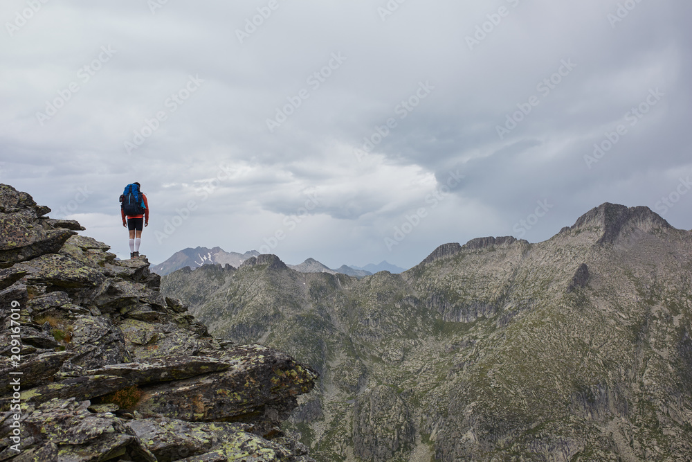 Young man backpacker enjoying the view of the mountains from a high altitude point Young man backpacker enjoying the view of the mountains from a high altitude point