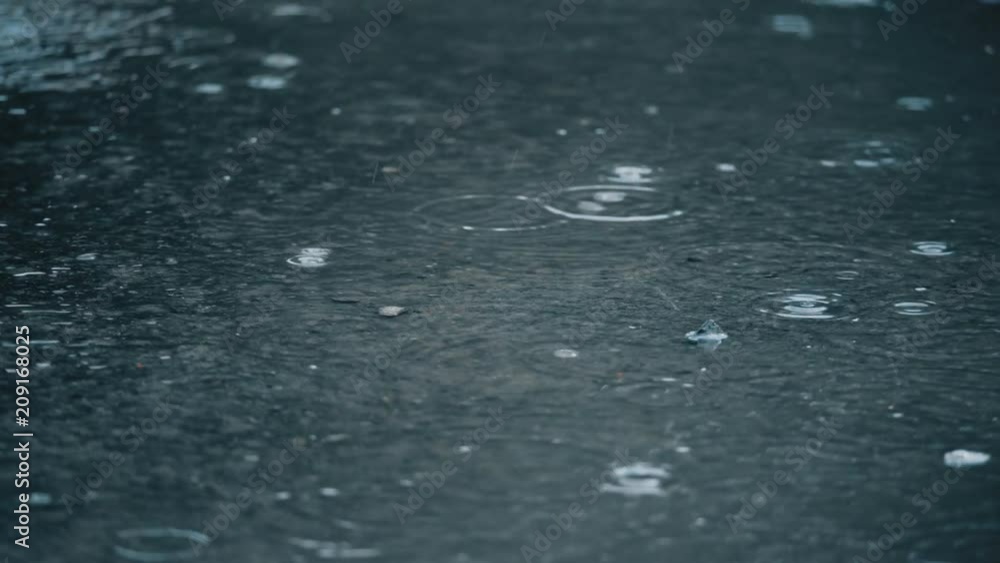 4K slow motion establishing shot of rain falling on pavement Stock ビデオ ...