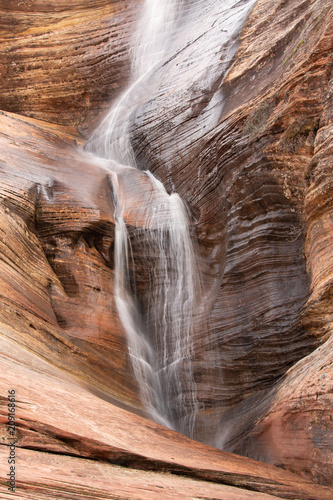 Temporary waterfall over red sandstone cliff caused by rain in Zion National park Utah
