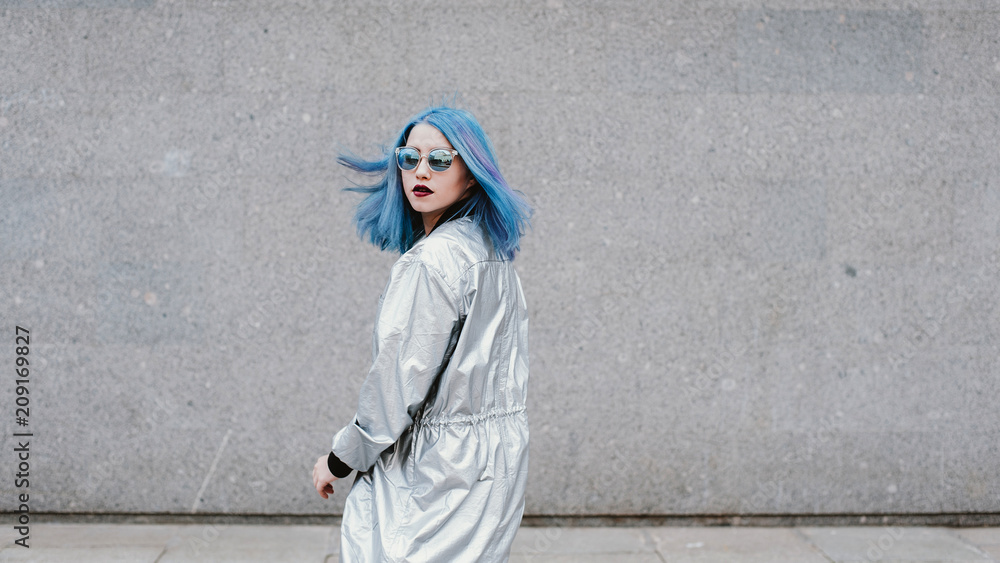 Young woman with blue hair looking over her shoulder Young woman with blue hair looking over her shoulder