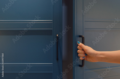 Women hand open a wardrobe cabinet.