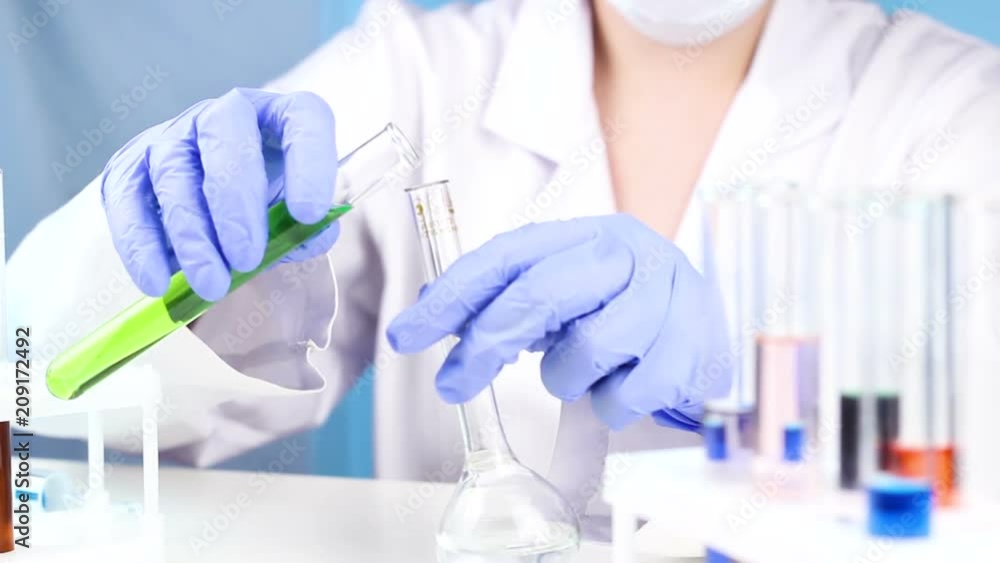 Scientist mixes the liquid from various samples. Scientist mixes the liquid from various samples.