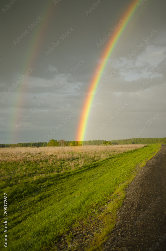 rainbow after rain against a backdrop of gloomy sky