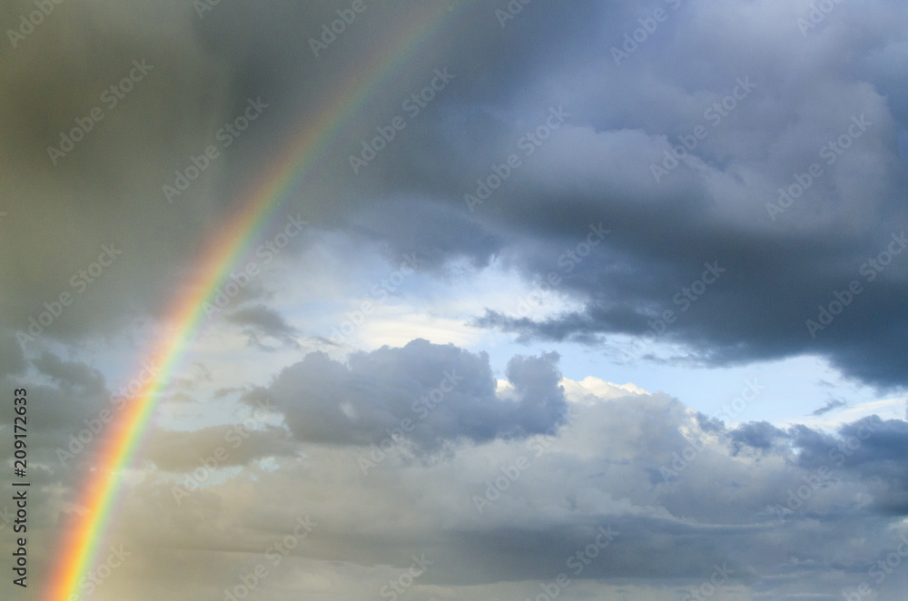 bright rainbow against a background of a rainy sky