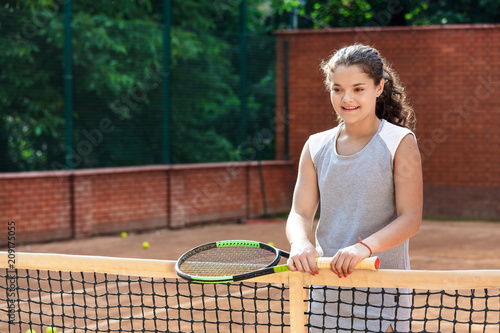 teenager tennis player girl training court girl racket ball brunette long hair sun portrait learn green summer green © NataliAlba