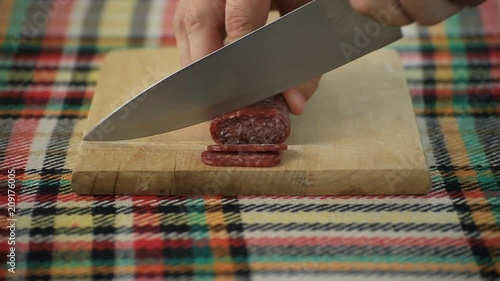 Cutting bulgarian flat sausage called lukanka photo