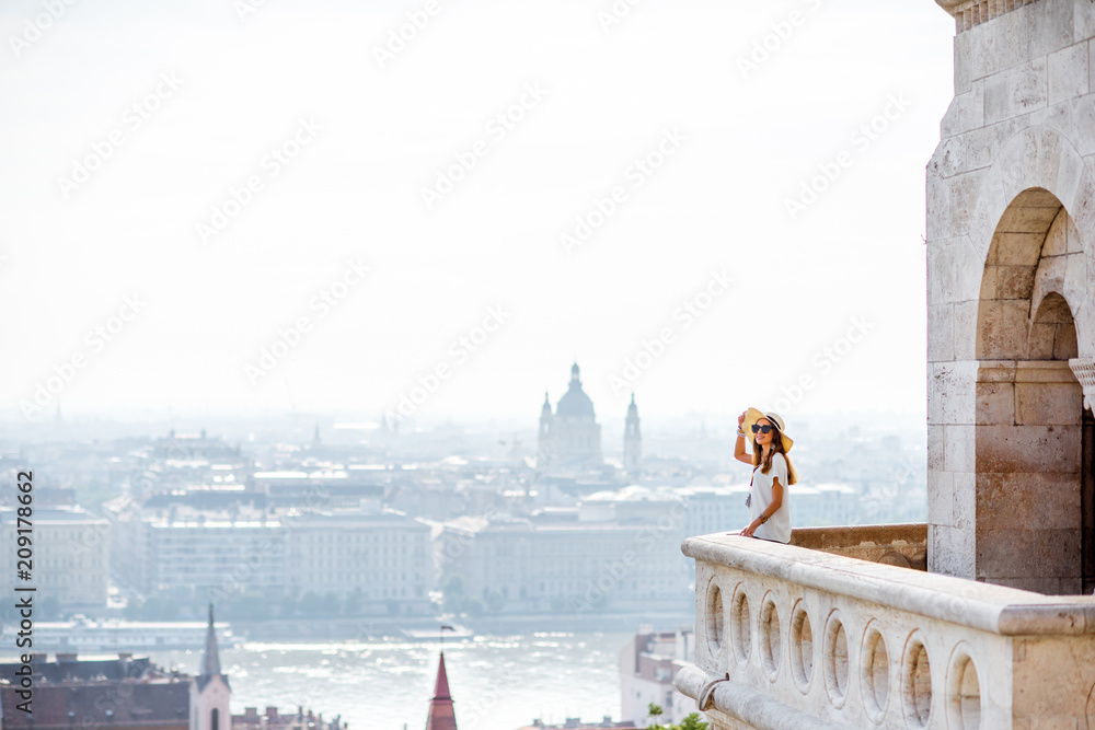 Obraz premium View on the wall of Fiserman's bastion with woman standing on the terrace enjoying great view on Budapest city in Hungary