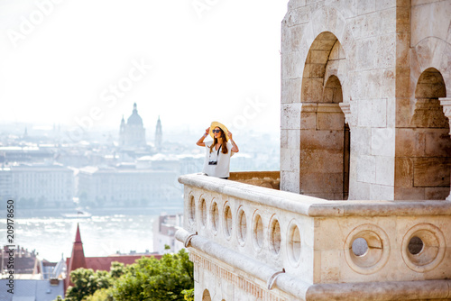 View on the wall of Fiserman's bastion with woman standing on the terrace enjoying great view on Budapest city in Hungary