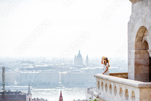 View on the wall of Fiserman's bastion with woman standing on the terrace enjoying great view on Budapest city in Hungary